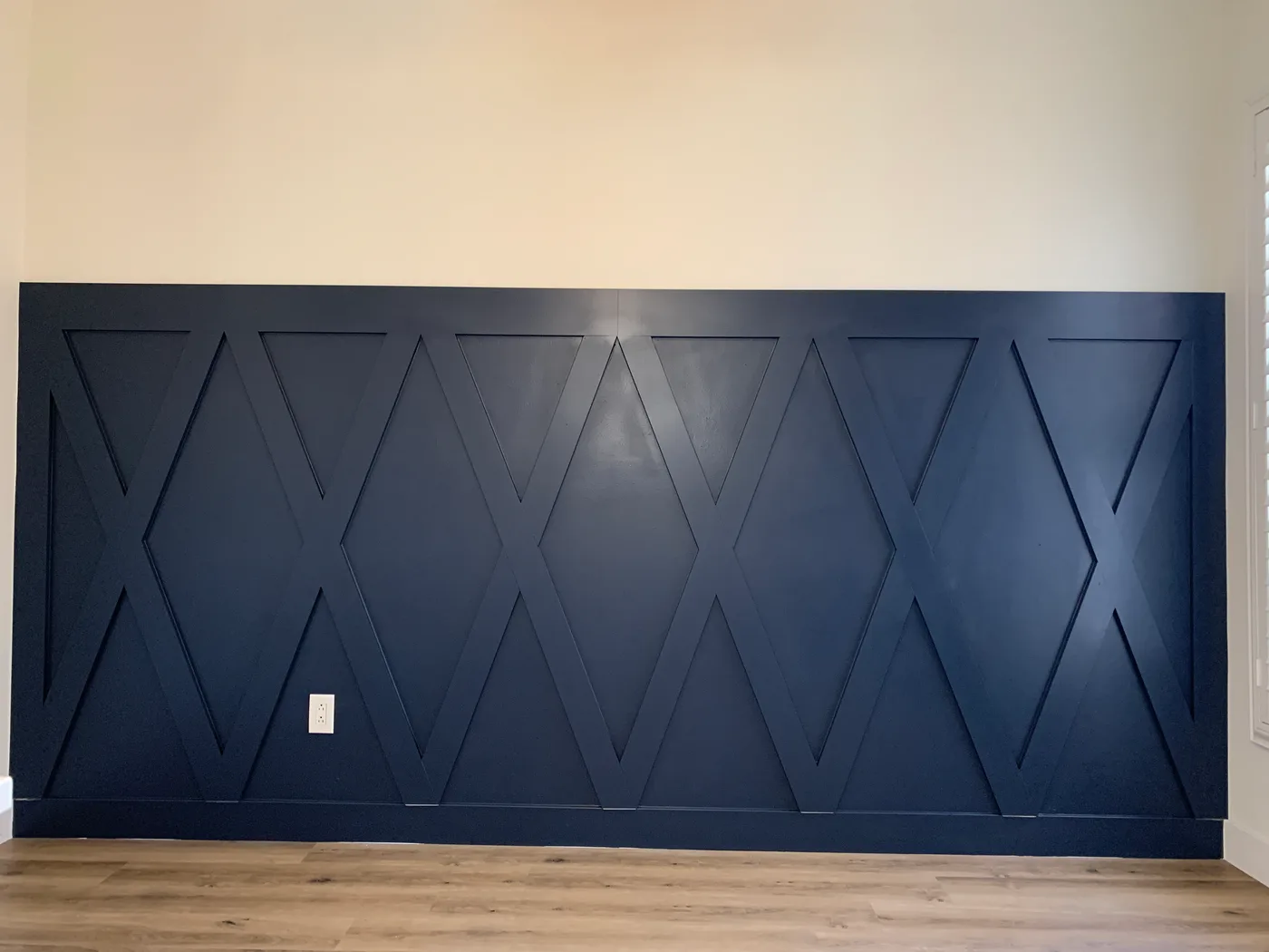 Deep blue bedroom accent wall with a geometric pattern of raised trim