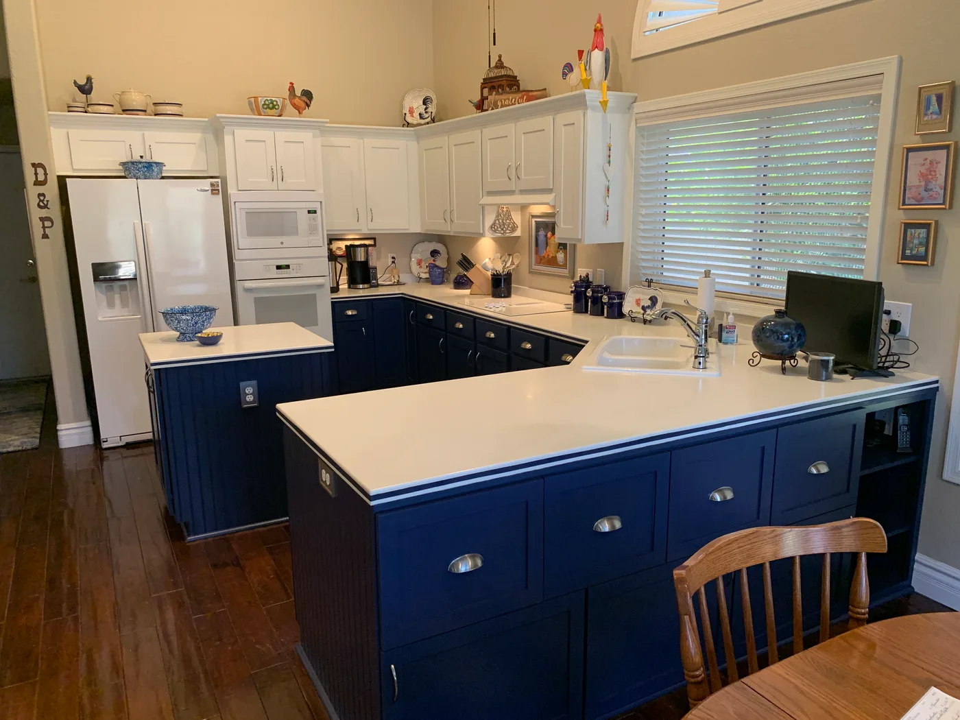 Kitchen with navy lower cabinets, white upper cabinets, and a peninsula countertop